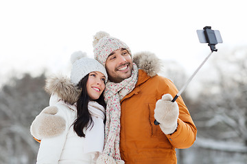 Image showing happy couple taking selfie by smartphone in winter