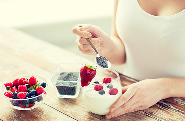 Image showing close up of woman hands with yogurt and berries