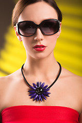 Image showing Lifestyle fashion portrait of stylish  young woman in trendy sunglasses ,bright  necklace . Summer bright colors.