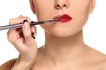 Image showing Beautiful female lips with make-up and brush