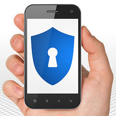 Image showing Security concept: Hand Holding Smartphone with Shield With Keyhole on display