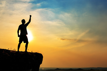 Image showing Man stands near the cross on top of mountain