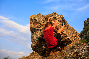 Image showing Young man climbing on a wall