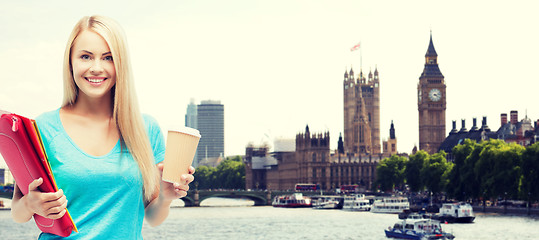 Image showing smiling student girl with folders and coffee cup