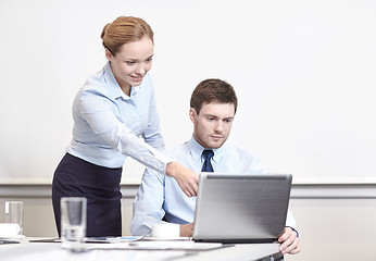 Image showing businessman and secretary with laptop in office