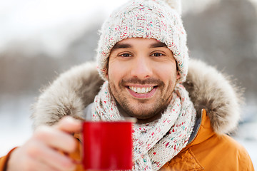 Image showing happy man with tea cup outdoors in winter