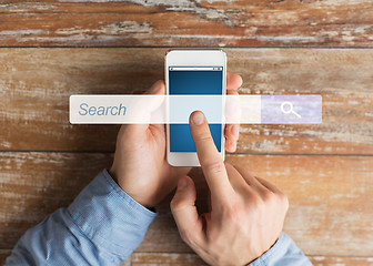 Image showing close up of male hands with smartphone on table