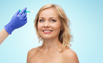 Image showing happy woman face and beautician hand with syringe