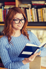 Image showing happy student girl reading book in library