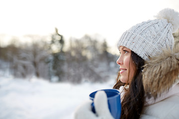 Image showing happy young woman with tea cup outdoors in winter