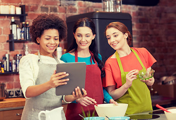 Image showing happy women with tablet pc cooking in kitchen