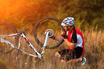 Image showing man repairing his mountain bike