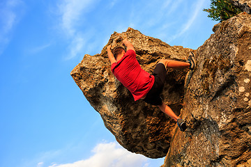 Image showing Young man climbing on a wall