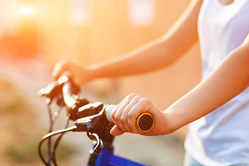 Image showing The hands of young woman sitting on bicycle