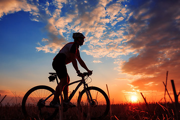 Image showing Man Cyclist with bike on sunset