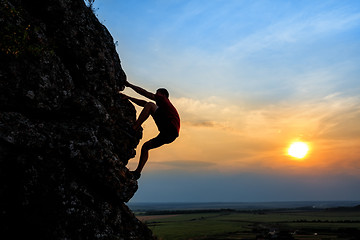 Image showing Young man climbing the mountain ridge