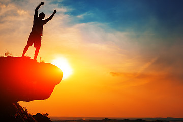 Image showing Man stands near the cross on top of mountain