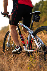 Image showing Cyclist with His Bike on the Autumn Meadow