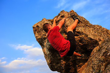 Image showing Young man climbing on a wall
