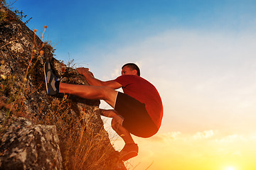 Image showing Young man climbing on a wall