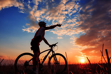 Image showing Man Cyclist with bike on sunset