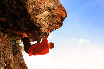 Image showing Young man climbing on a wall