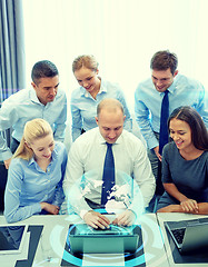 Image showing smiling business people with laptop in office