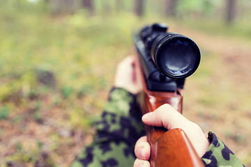 Image showing close up of soldier or hunter with gun in forest