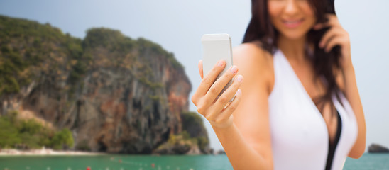 Image showing young woman taking selfie with smartphone on beach