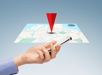 Image showing close up of hand with smartphone and navigator map