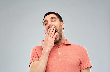 Image showing yawning man over gray background