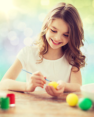 Image showing happy girl with brush coloring easter eggs