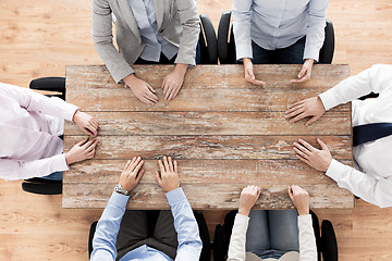 Image showing close up of business team sitting at table