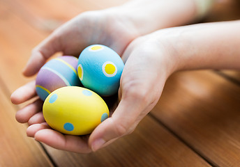 Image showing close up of woman hands with colored easter eggs