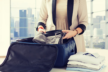 Image showing woman packing formal male clothes into travel bag