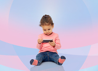 Image showing smiling little baby girl playing with smartphone