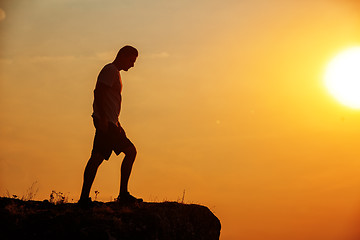 Image showing Man stands near the cross on top of mountain