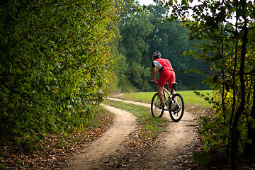 Image showing Cyclist riding mountain bike on trail at evening.