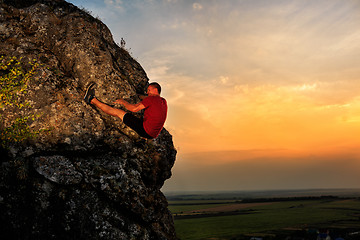 Image showing Young man climbing on a wall