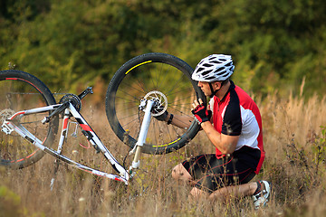 Image showing man repairing his mountain bike