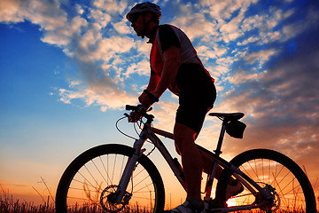 Image showing Man Cyclist with bike on sunset