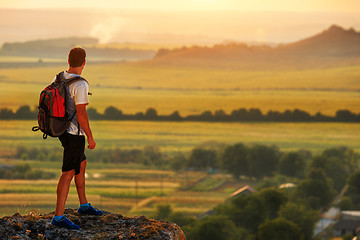 Image showing Hiker with backpack standing on top of a mountain