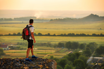 Image showing Hiker with backpack standing on top of a mountain