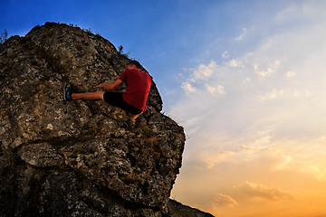 Image showing Young man climbing on a wall