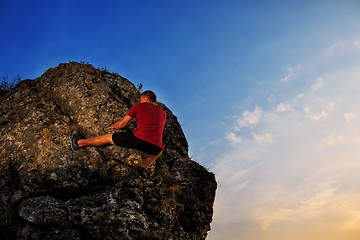 Image showing Young man climbing on a wall