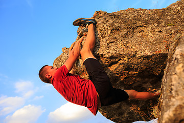 Image showing Young man climbing on a wall