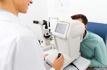 Image showing optician with autorefractor and patient at clinic