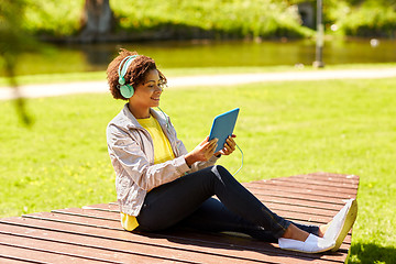 Image showing happy african woman with tablet pc and headphones