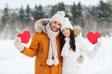 Image showing happy couple with red hearts over winter landscape