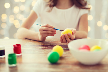 Image showing close up of girl with brush coloring easter eggs